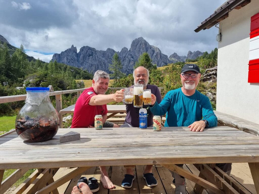 Comemorando o final da trilha do dia no Refugio sommariva com as montanhas ao fundo