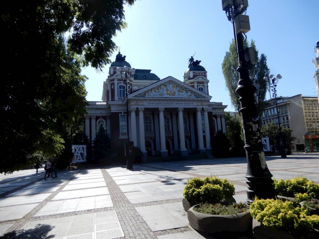 Em frente ao Teatro IvaVazo National prédio com arquitetura da união soviética.